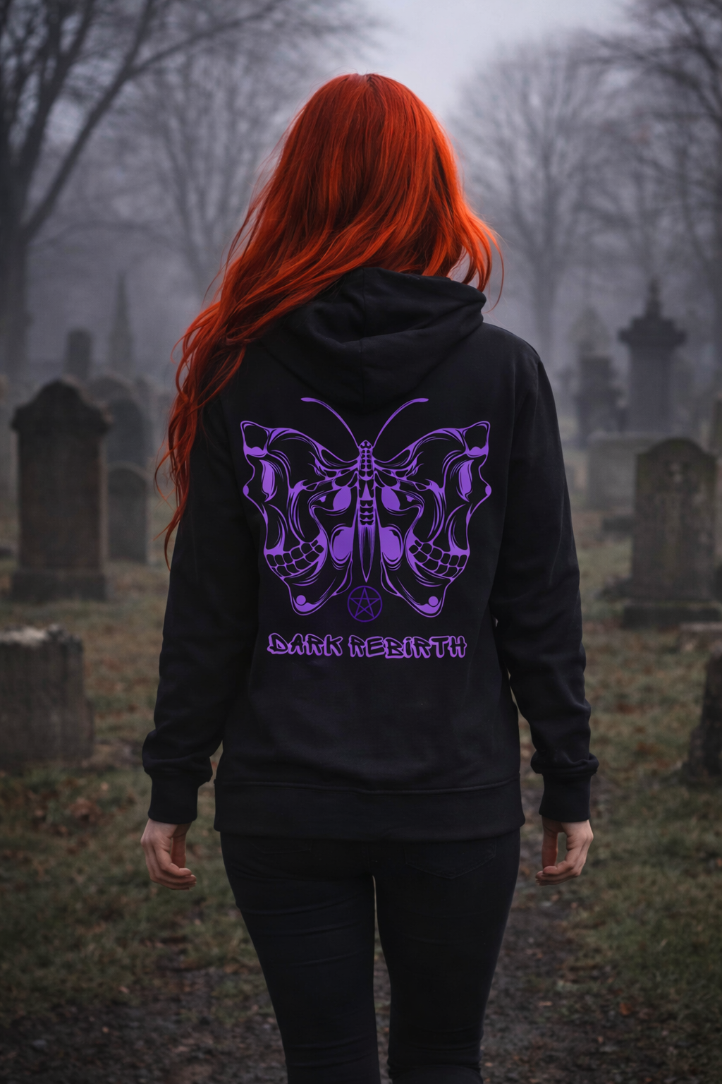 Person with red hair wearing a black hoodie with a purple butterfly design in a cemetery
